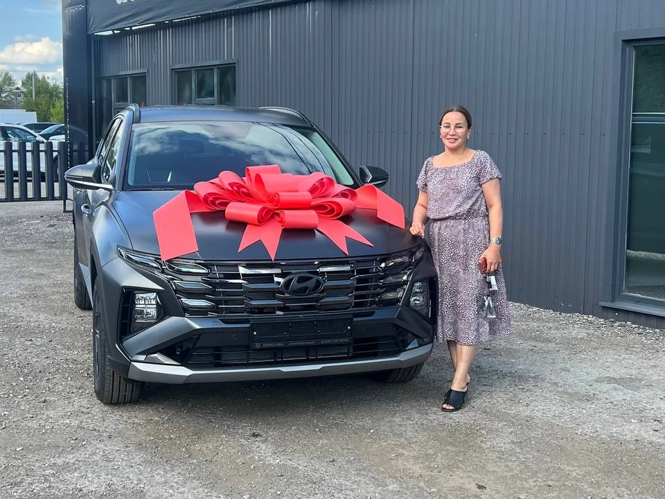 Клиент автосалона рядом с приобретённым автомобилем Hyundai